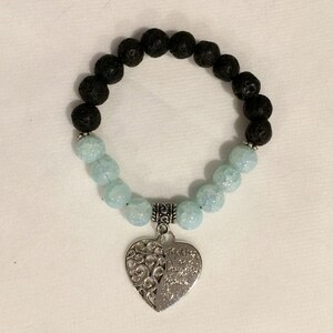 May include: A black lava rock and light blue agate beaded bracelet with a silver heart charm that reads "My Mother, My Daughter, Forever Friends".