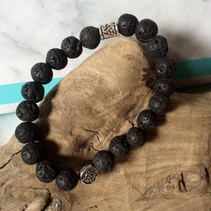 May include: Black lava rock beaded bracelet with silver Celtic knot charms.