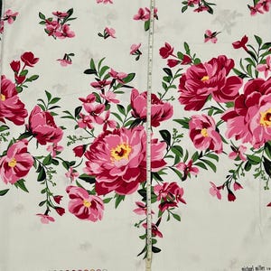 May include: White fabric with a pink and green floral print. The fabric features large pink peonies and smaller pink flowers with green leaves. The fabric is measured with a ruler in inches. The text "michael miller" is visible in the bottom right corner.