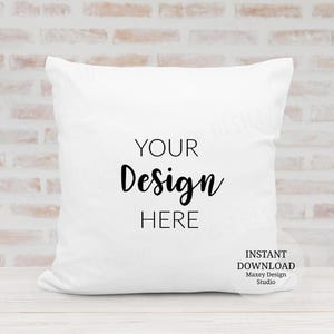 May include: A white square pillow with the words "YOUR Design HERE" in black script. The pillow is on a white wooden surface with a brick wall background. The words "INSTANT DOWNLOAD Maxey Design Studio" are also visible.
