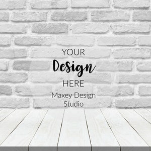 May include: White brick wall background with a white wood plank surface in the foreground. The text "YOUR Design HERE Maxey Design Studio" is superimposed on the wall.
