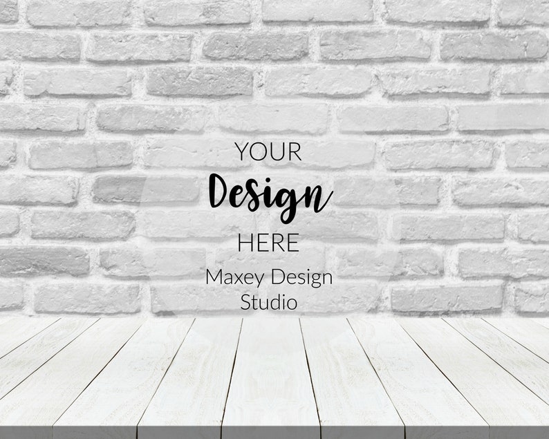 May include: White brick wall background with a white wood plank surface in the foreground. The text "YOUR Design HERE Maxey Design Studio" is superimposed on the wall.