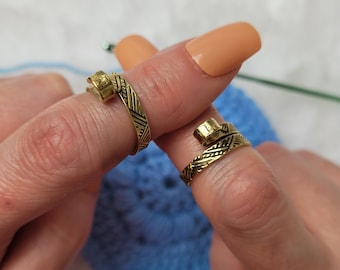 Worked gold-colored crochet or knitting ring, a yarn tension aid for crocheting and knitting.