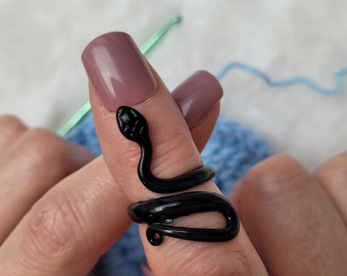 Left-handed black snake crochet or knitting ring a yarn tension aid for crocheting and knitting.