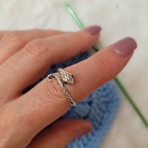 silver-colored snake crochet or knitting ring, a yarn tension aid for crocheting and knitting.