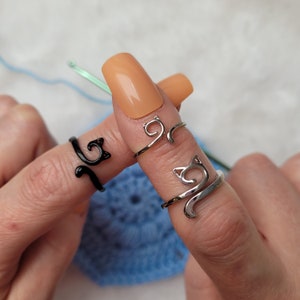 Cat crochet or knitting ring is a yarn tension aid for crocheting and knitting. Three different variations silver, gray/black and silver narrow