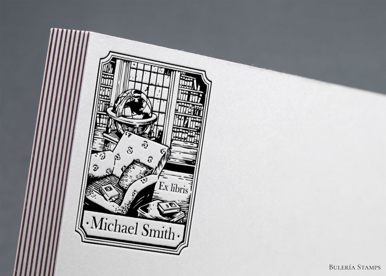 May include: Black and white illustration of a bookplate featuring a globe, bookshelves, a chair, and books. The text "Ex libris" and "Michael Smith" are included in the design.