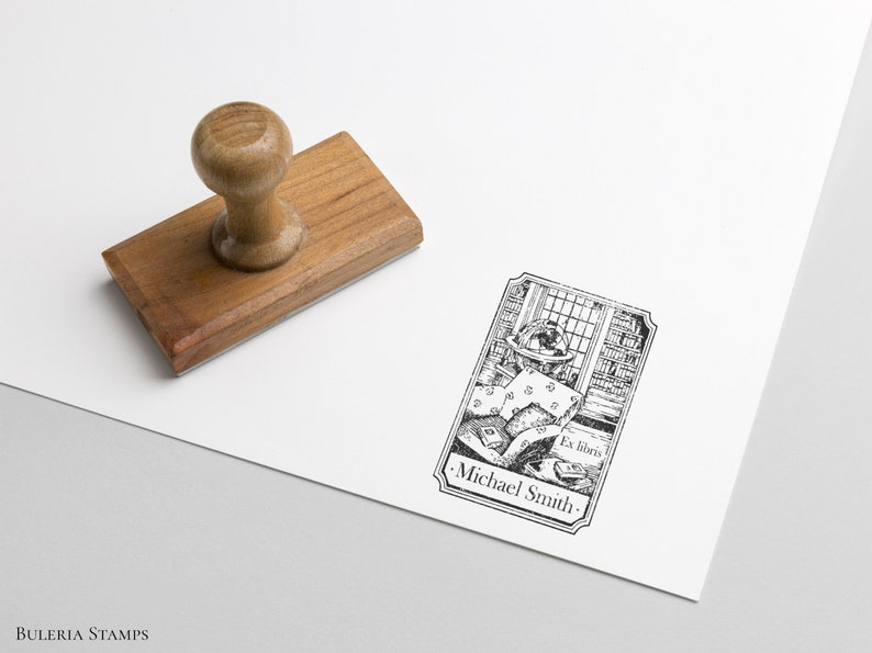 May include: A wooden rubber stamp with a black and white illustration of a person reading in a library. The illustration includes the text "Ex libris" and "Michael Smith".