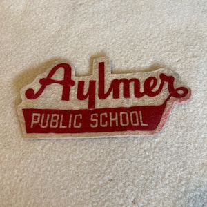 May include: Red felt patch with the text "Aylmer Public School" in white lettering.