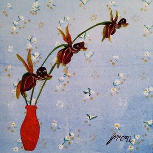 May include: A painting of three dark red orchids in a red vase against a light blue background with a white floral pattern. The painting is signed "jmccou".