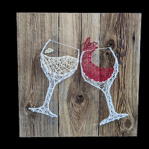 May include: Two wine glasses made of string art on a wooden background. One glass is filled with white string and the other with red string.