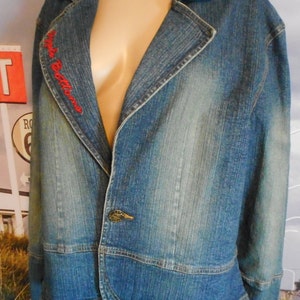 May include: A blue denim jacket with a red embroidered logo that says "Style Editions".