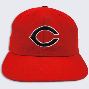 Puede incluir: Una gorra de béisbol roja con un logotipo "C" en blanco y negro.