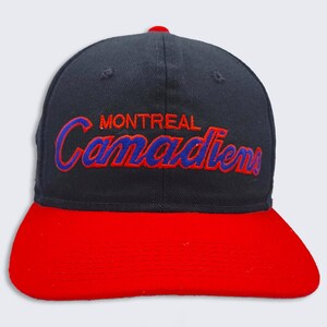 May include: A black and red baseball cap with the embroidered text "MONTREAL Canadiens" in blue and red.