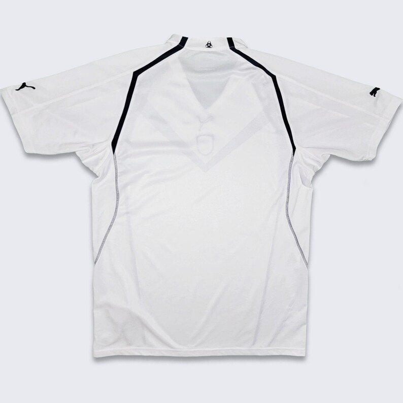K&ouml;nnte beinhalten: Wei&szlig;es Fu&szlig;balltrikot mit schwarzem Besatz und einem Puma-Logo auf der Schulter.