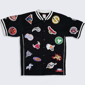May include: Black button-up jersey with white trim and numerous NBA team logo patches. The jersey features a white collar and sleeves with black and white stripes. Patches include the Celtics, Raptors, and Bulls.