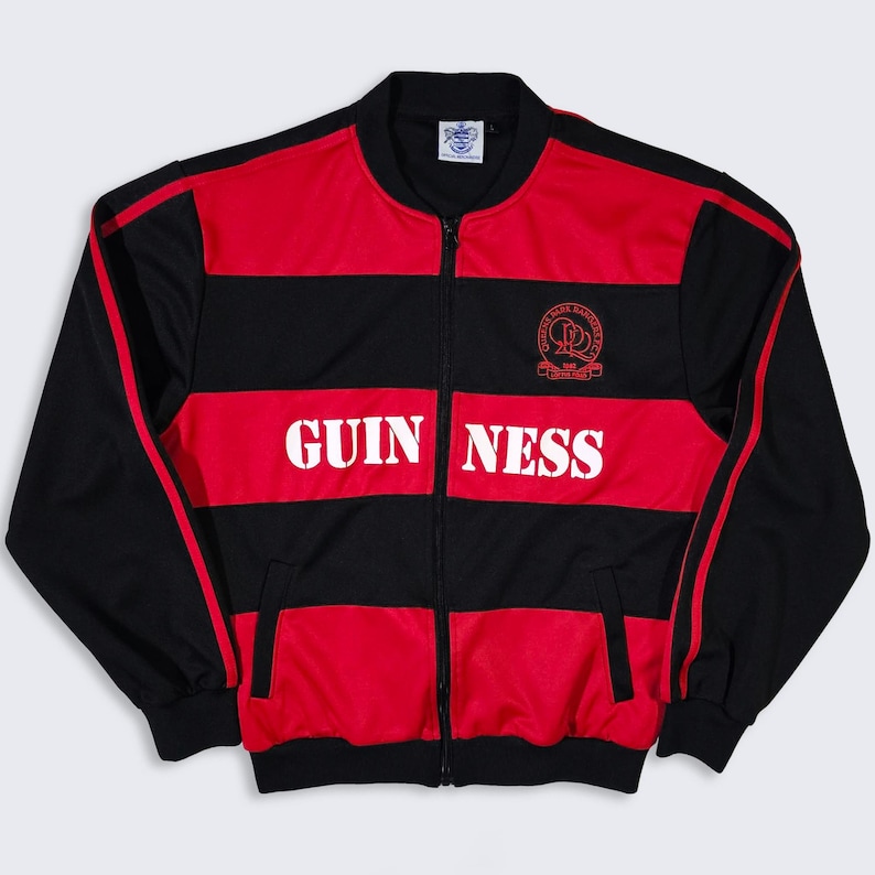 K&ouml;nnte beinhalten: Schwarz-rote Trainingsjacke mit Rei&szlig;verschluss und dem Wort "GUINNESS" in wei&szlig;en Blockbuchstaben auf der Vorderseite. Die Jacke hat einen roten Streifen an den &Auml;rmeln und ein Logo auf der oberen Brust. Gr&ouml;&szlig;e M.