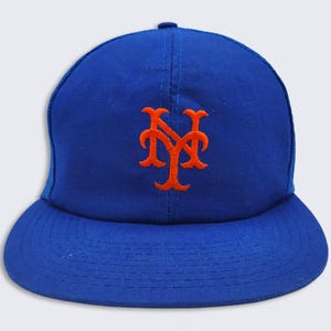 May include: A blue baseball cap with an orange embroidered New York Mets logo.