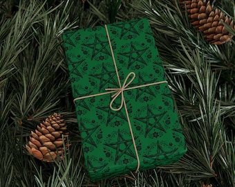 May include: A wrapped gift with green paper featuring a black pentagram and floral pattern. The gift is tied with twine and rests on a bed of pine needles and pine cones. The overall theme is a mystical or occult aesthetic.
