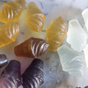 May include: Assortment of colorful gummy candies shaped like ice cream cones. The candies are in shades of yellow, brown, purple, and white.