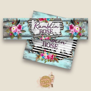 May include: A distressed wood sign with black and white stripes and a floral design. The sign says "Ramblin' ROSE" in purple and white lettering.