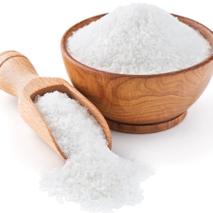 May include: A wooden bowl filled with white salt, with a wooden scoop overflowing with salt beside it.