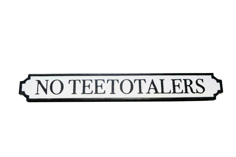 May include: A white sign with black lettering that reads "NO TEETOTALERS". The sign is shaped like a street sign with rounded edges.