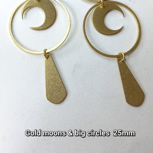 Op de afbeelding: Goudkleurige oorbellen met maan- en cirkelontwerpen, met een druppelvormige hanger. De oorbellen zijn ongeveer 25 mm groot. De tekst "Gold moons & big circles" is zichtbaar in de afbeelding.