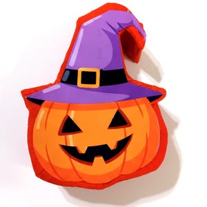 May include: A Halloween-themed plush pumpkin with a witch's hat. The pumpkin is orange with a carved face, and the hat is purple with a black band and gold buckle. The edges are trimmed in red.