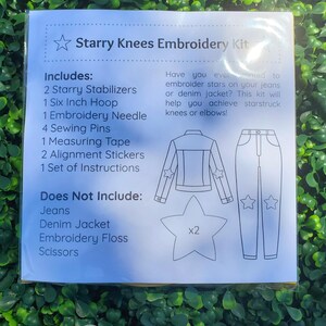 May include: A white package labeled "Starry Knees Embroidery Kit" with a list of included items, including a 6-inch hoop. The kit includes stabilizers, a needle, pins, a measuring tape, and stickers. The package also shows a denim jacket and jeans with star embroidery.