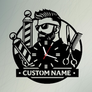 Könnte beinhalten: Schwarze Metall-Wanduhr für einen Friseursalon. Sie zeigt einen stilisierten Barbier mit Sonnenbrille und Bart, in dessen Torso ein Ziffernblatt integriert ist. Schere, Kamm und eine Barbierstange sind ebenfalls abgebildet. Der Text "CUSTOM NAME" ist zu sehen.