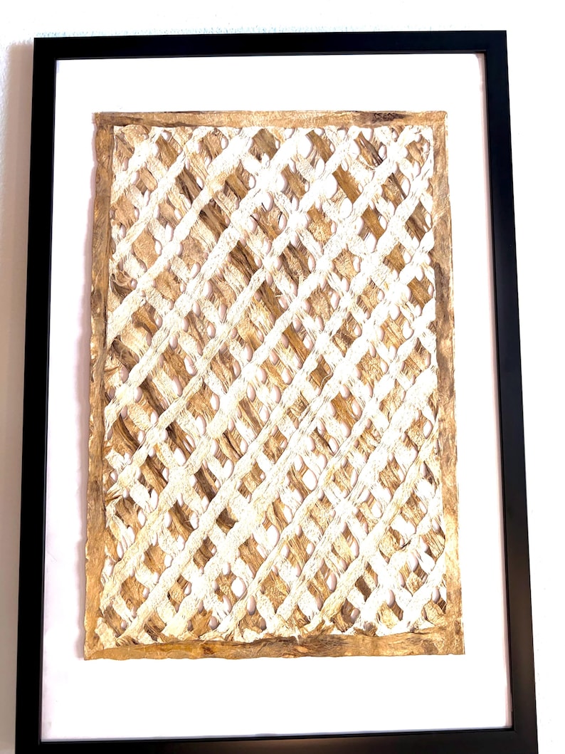 May include: Framed artwork featuring a woven, lattice-like design in natural beige and white tones. The artwork is encased in a white mat and a black frame, creating a modern and textured aesthetic. The piece is suitable for home decor.
