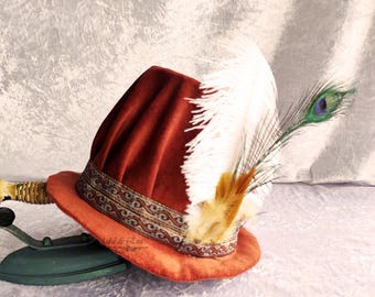 Gorra aderezada, renacentista, del siglo XVI, hecha de terciopelo color teja con ala pequeña, con plumas naturales. Sombrero renacentista