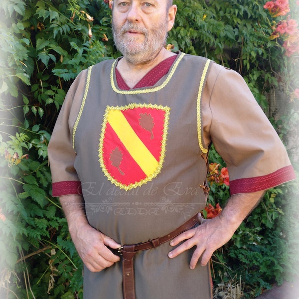 Medieval surcoat made of imitation leather, decorated with a shield and trimmed with gold trimmings. Surcoat with blazon. Medieval Vesta.