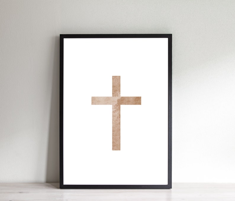 May include: A framed print of a brown watercolor cross on a white background.