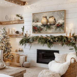 May include: A cozy living room scene with a Christmas tree, fireplace, and artwork. The artwork features two birds perched on a snow-covered branch. The fireplace is decorated with greenery and candles, creating a warm and inviting atmosphere.