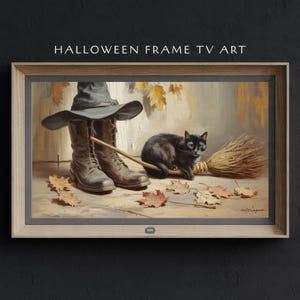 Könnte beinhalten: Gerahmter Halloween-TV-Kunstdruck. Das Kunstwerk zeigt eine schwarze Katze, Hexenstiefel, einen Hut und einen Besen. Der Text "HALLOWEEN FRAME TV ART" steht oben. Herbstblätter liegen auf dem Boden verstreut.