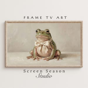 Könnte beinhalten: Gerahmter digitaler Kunstdruck mit einem grünen Frosch, der eine cremefarbene Fliege trägt. Das Kunstwerk, mit dem Text "FRAME TV ART" oben und "Screen Season Studio" unten, hat eine Vintage-Ästhetik. Der Frosch ist das zentrale Motiv.