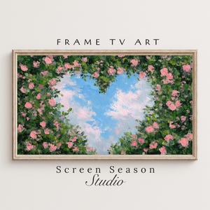 May include: Framed TV art featuring a heart-shaped opening in a lush green and pink floral arrangement. The sky is visible through the heart, with blue and white clouds. The text "FRAME TV ART" and "Screen Season Studio" are displayed.