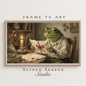 Könnte beinhalten: Ein gerahmtes Kunstwerk zeigt einen Frosch in einem weißen Hemd, der an einem Schreibtisch einen Brief liest. Eine brennende Kerze, Bücher und Blumen befinden sich ebenfalls auf dem Schreibtisch. Das Kunstwerk trägt den Text "FRAME TV ART" und "Screen Season Studio".