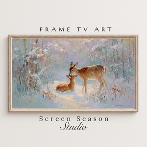 Könnte beinhalten: Gerahmtes Gemälde mit zwei Hirschen in einer verschneiten Waldszene. Das Kunstwerk zeigt eine Hirschmutter und ein Jungtier, mit dem Text "FRAME TV ART" und "Screen Season Studio" oben und unten am Rahmen.