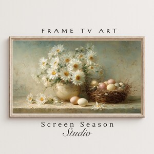 Könnte beinhalten: Gerahmter digitaler Kunstdruck mit einem Stillleben mit weißen Gänseblümchen in einer cremefarbenen Vase, einem geflochtenen Korb mit Eiern und losen Eiern. Der Text "FRAME TV ART" und "Screen Season Studio" sind sichtbar.