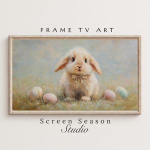 Könnte beinhalten: Gerahmter digitaler Kunstdruck mit einem flauschigen, hellbraunen Hasen mit Fliege, umgeben von pastellfarbenen Ostereiern auf einer Wiese. Der Text "FRAME TV ART" und "Screen Season Studio" ist auf dem Bild zu sehen.