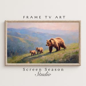 Könnte beinhalten: Gerahmtes Landschaftsgemälde, das einen Braunbären und zwei Jungtiere zeigt, die auf einem grasbewachsenen Hügel gehen. Der Hintergrund zeigt sanfte Hügel und einen Himmel in Pastellfarben. Der Text "FRAME TV ART" und "Screen Season Studio" sind sichtbar.
