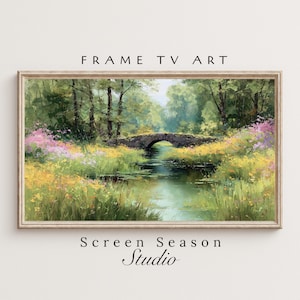 May include: Framed landscape art print featuring a serene river scene with a stone bridge. The artwork showcases lush greenery, colorful wildflowers, and the text "FRAME TV ART" and "Screen Season Studio". The frame is a light wood color.