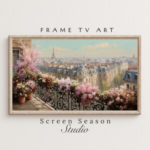 May include: A framed art print depicting a Parisian cityscape with the Eiffel Tower in the distance. The artwork features a balcony with pink flowers and a wrought iron railing. The text "FRAME TV ART" and "Screen Season Studio" are displayed.