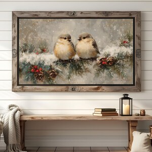 May include: A framed painting depicts two small birds perched on a snow-covered branch with pine needles, red berries, and pine cones. The artwork has a rustic, wintery theme, with a wooden frame.