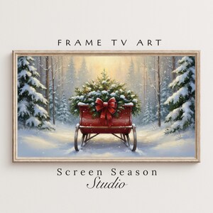 May include: A framed digital art print featuring a winter scene with a red sleigh filled with a Christmas tree and a large red bow. The artwork is set in a snowy forest with the text "FRAME TV ART" and "Screen Season Studio".