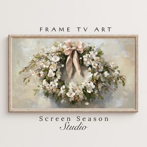 Könnte beinhalten: Gerahmtes Gemälde eines floralen Kranzes mit weißen Blüten, grünen Blättern und einer beigen Schleife. Das Kunstwerk ist oben mit "FRAME TV ART" und unten mit "Screen Season Studio" beschriftet. Das Gemälde hat eine weiche, neutrale Farbpalette.