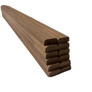 May include: A stack of 10 unfinished wooden strips with rounded edges. The strips are a light brown colour and are stacked neatly.